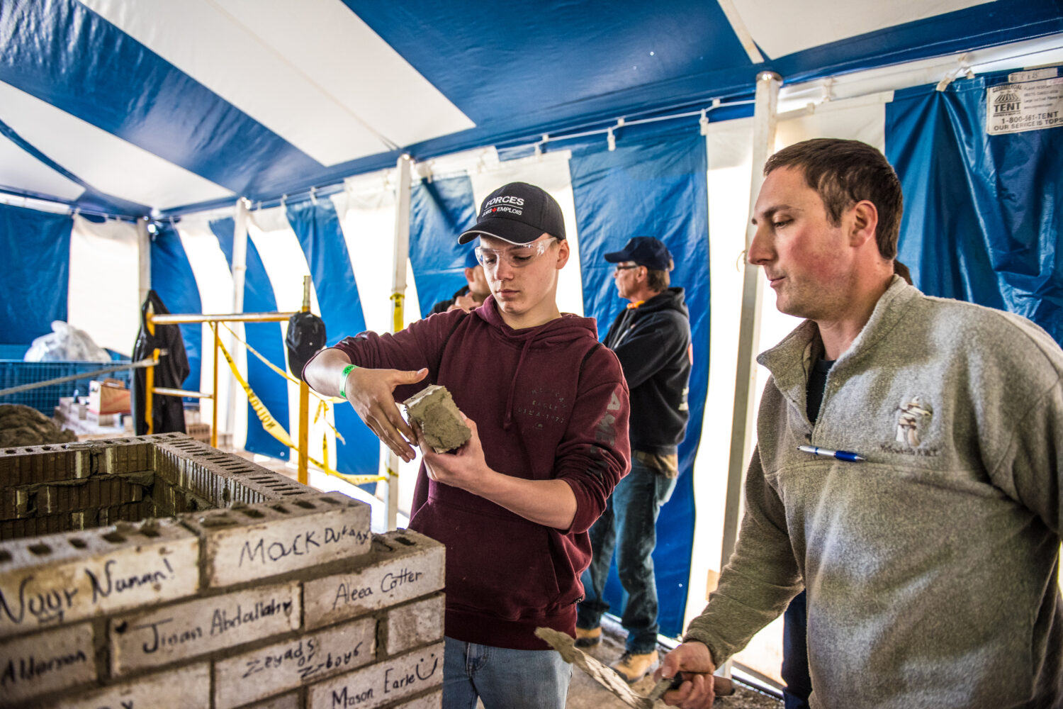 Student working on placing a buttered brick