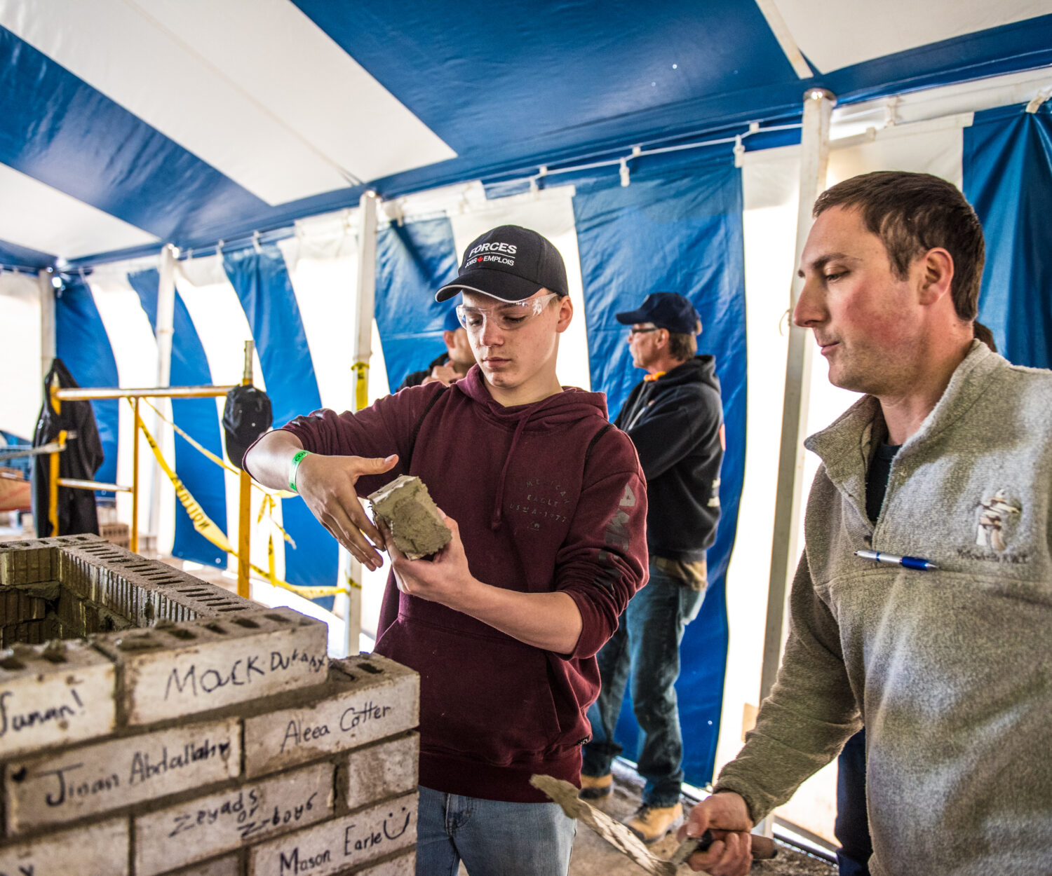 Student working on placing a buttered brick